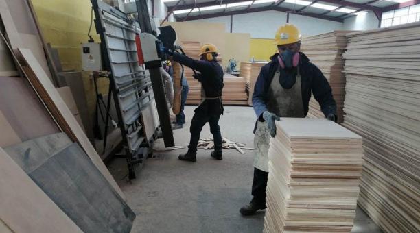 Los obreros preparan las tablas tríplex con las que luego dan forma al féretro